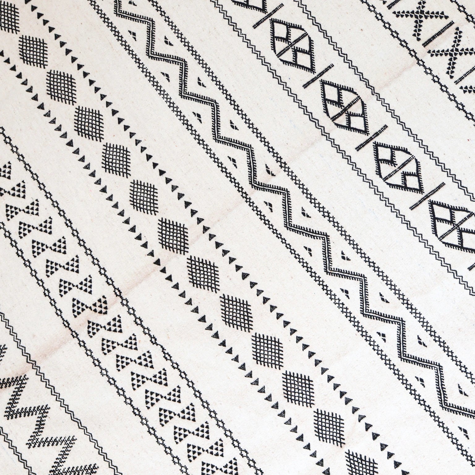 Close-up of black geometric patterns on a white fabric background