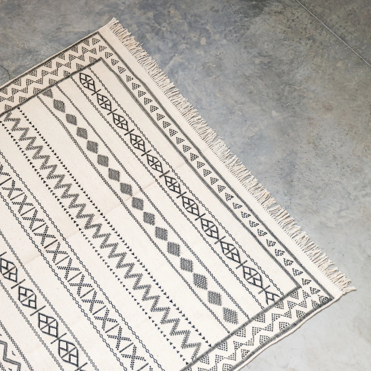 Patterned rug with geometric design on a concrete floor