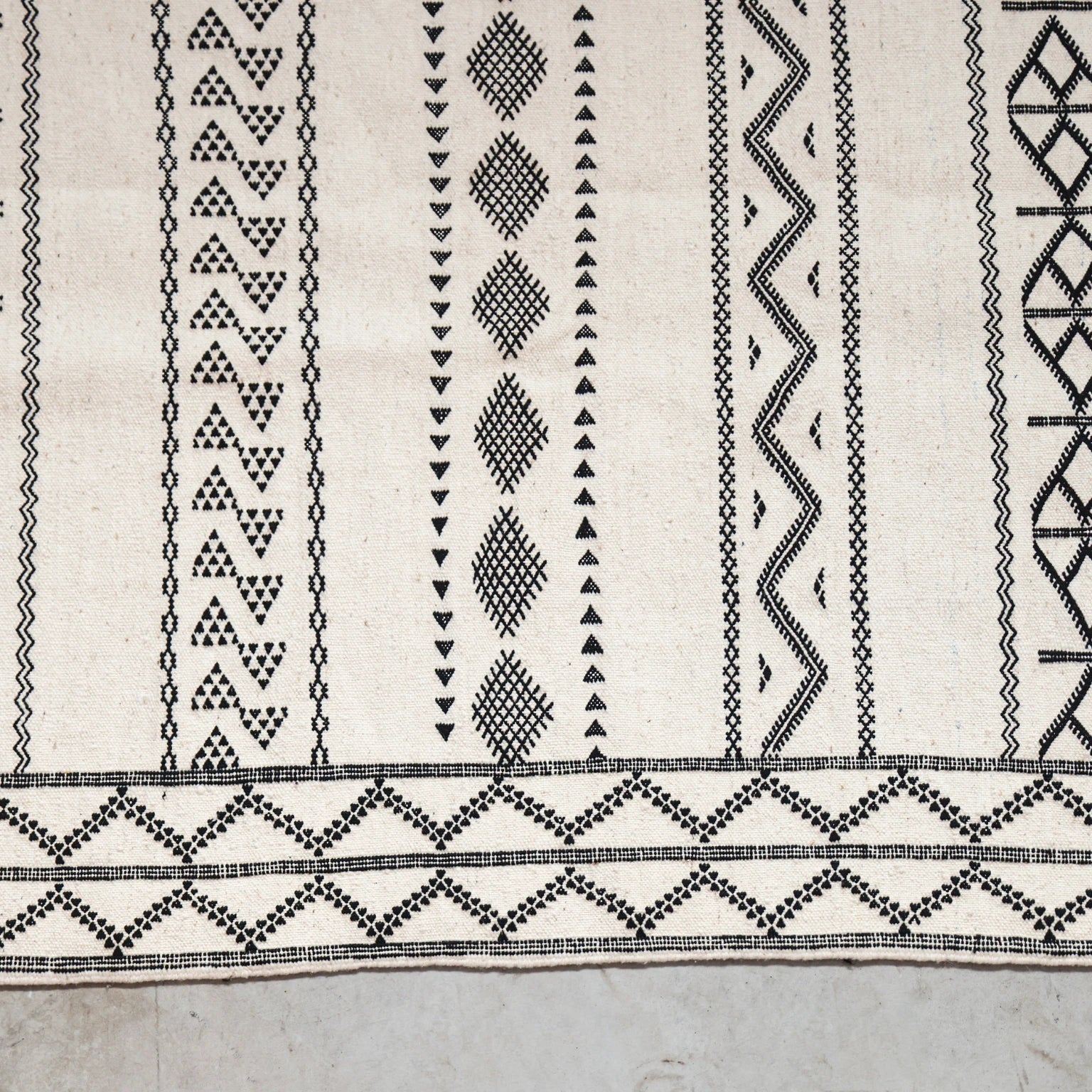 Close-up of a textured fabric with black geometric patterns on a light background