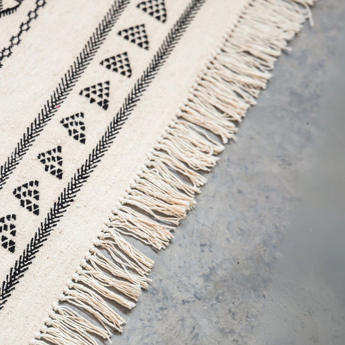 Textile with geometric pattern and fringes on a neutral background